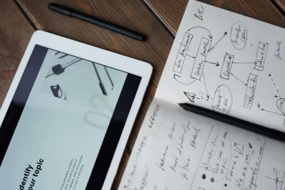 A tablet and a notepad with scribbled writing - showing how B2B marketing plans can sometimes be complicated.